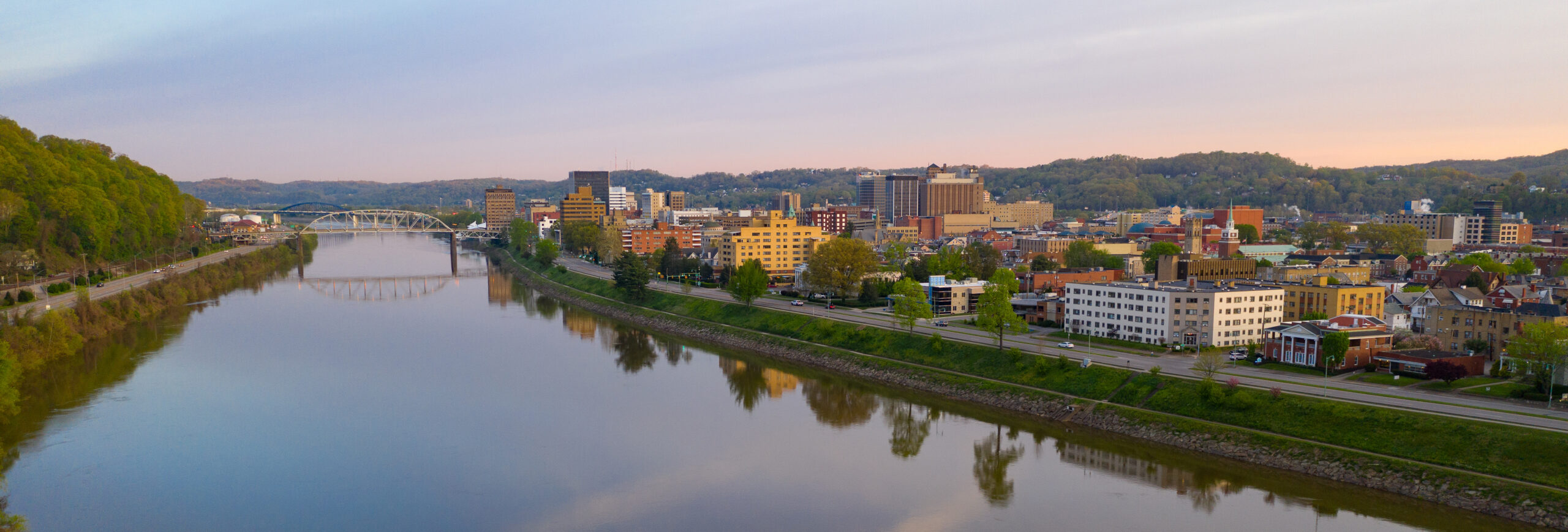 Sunrise reflects in the Kanawha River slowly flowing by picturesque Charleston, West Virginia downtown.